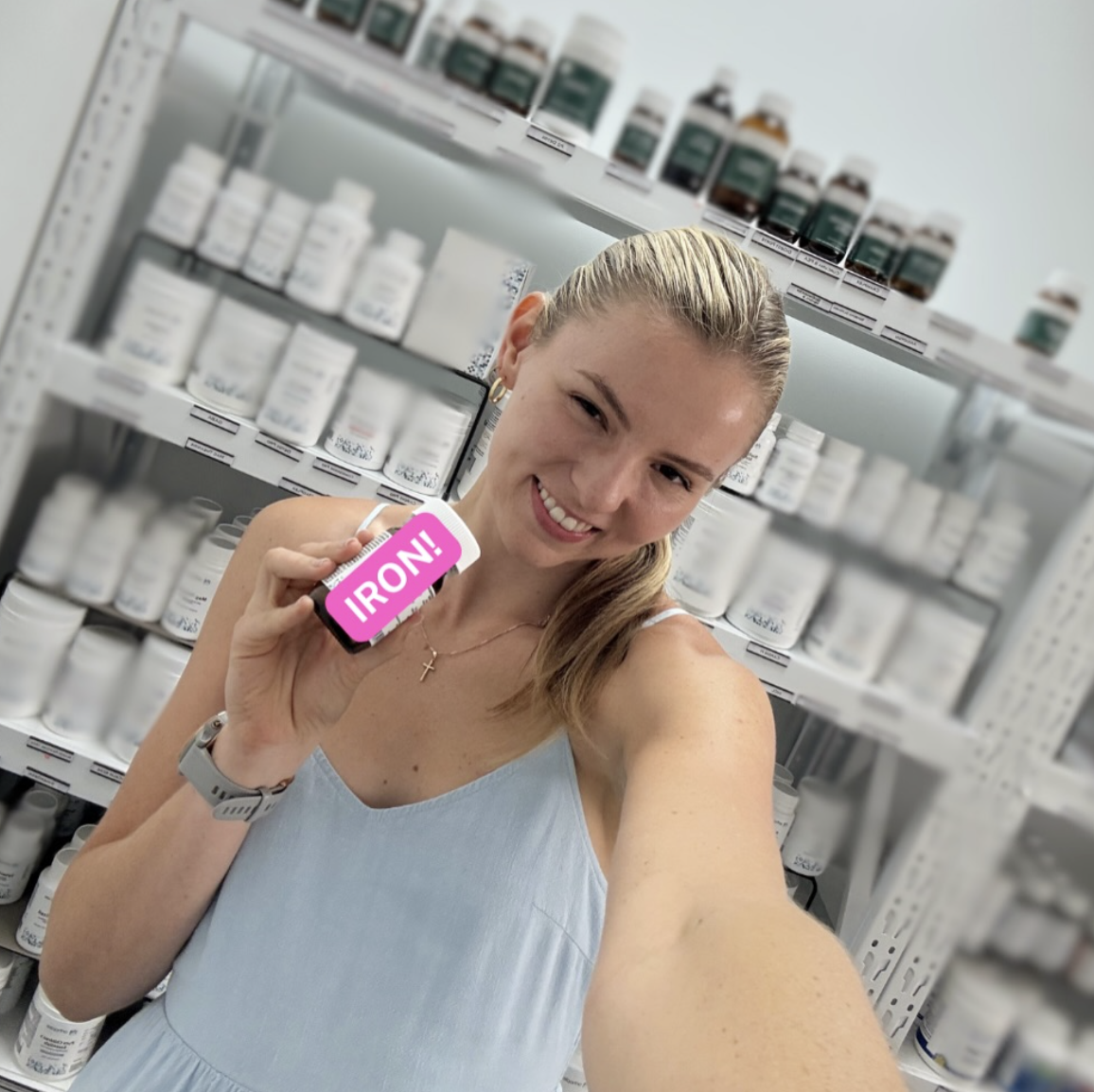 Amy Angus naturopath with iron supplement in dispensary